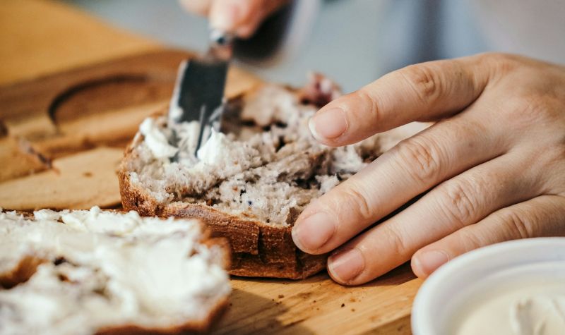 mand smører let frokost på arbejdet